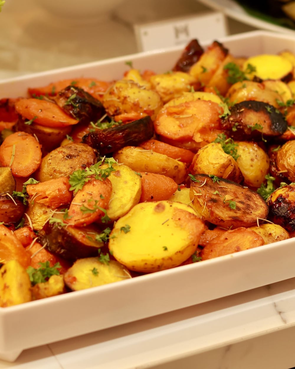 Plat de pommes de terre grenailles et de légumes rôtis aux herbes, sorti du four.