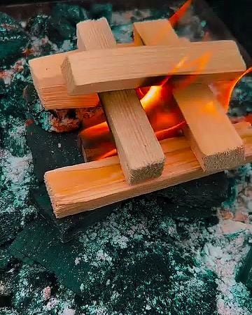 Bûchettes de bois empilées en train de prendre feu.